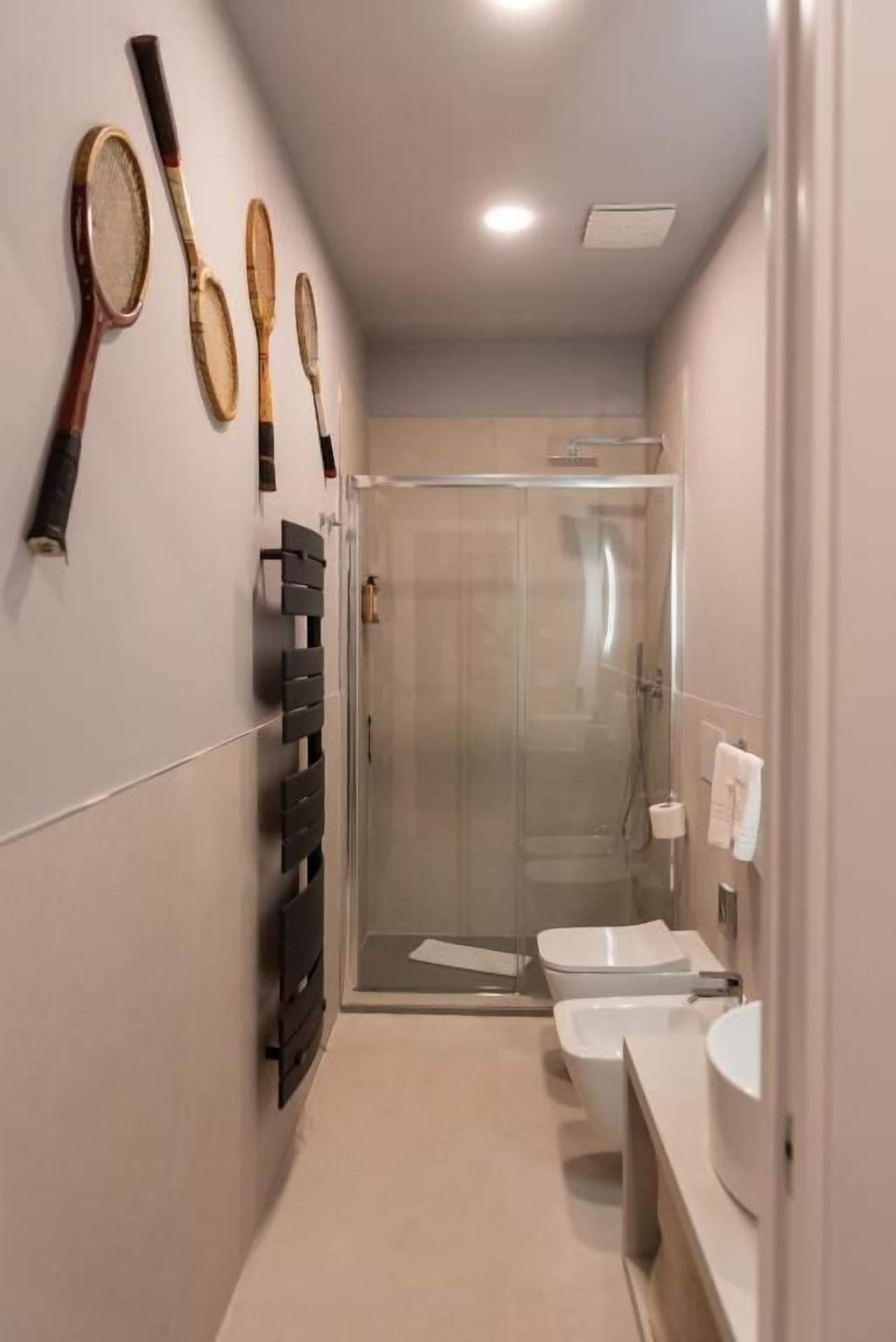 Ein modernes Badezimmer mit Duschkabine aus Glas, Toilette und Waschbecken.