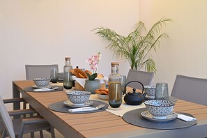 Una mesa de comedor con boles estampados, una tetera y una planta en maceta.
