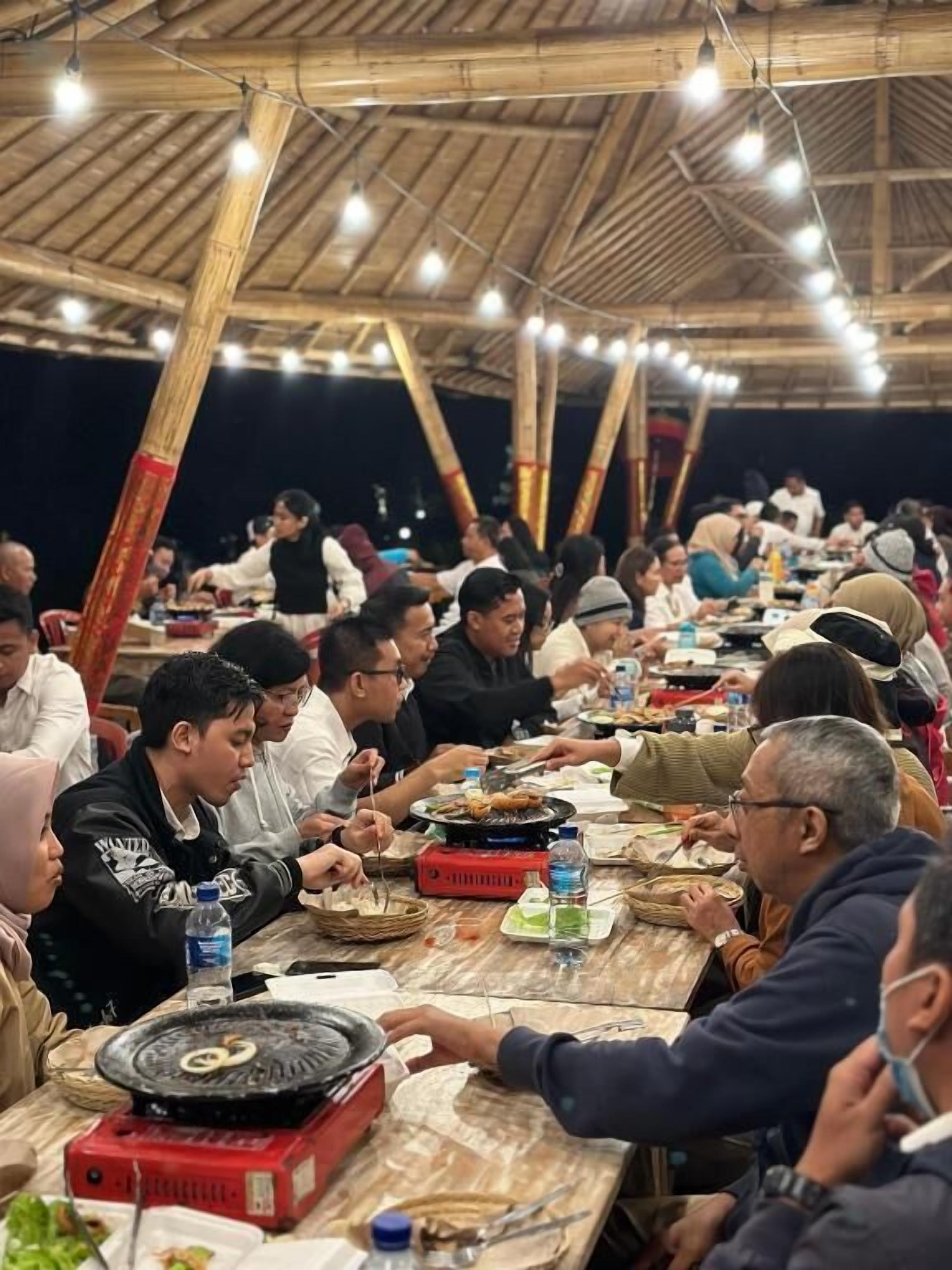 A communal dining area with bamboo structures and string lights.