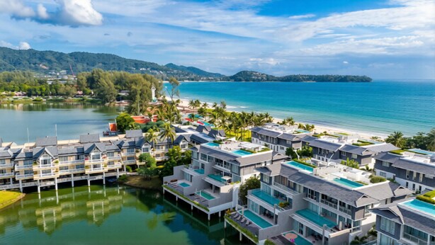 Um resort com edifícios de vários andares, piscina e vista para o oceano.