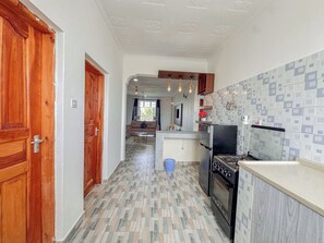 Une cuisine équipée d’une cuisinière, d’un réfrigérateur et de meubles de rangement en bois.