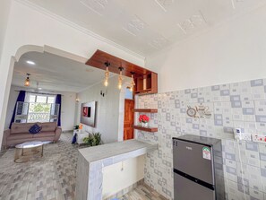 Une cuisine moderne équipée d’un réfrigérateur, d’un plan de travail en bois et d’un revêtement mural en carreaux.