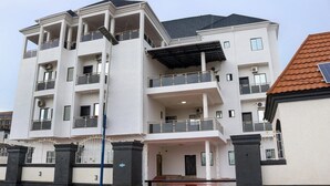 A multi-story residential building with balconies, a covered entrance, and a gated driveway. - VICTORIAN BLOOM HOTEL AND RESORT (Asaba)