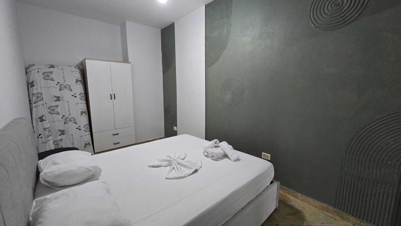 Ein Hotelzimmer mit einem Bett, einem Kleiderschrank und einer Wand mit kreisförmigen Mustern.