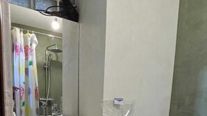 A bathroom with a white sink, a mirror, a shower, and a toilet. There is a black trash bin under the sink. - Tirent Apartment-One Bedroom Central (Tirana)