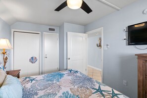A bedroom with a bed, a ceiling fan, a TV, and a door. - Tradewinds - Laguna Reef Waterfront Condo unit 305 (Rockport)
