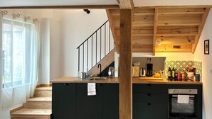 Eine Küche mit Holztreppe, Spüle und gefliestem Rücksprung.