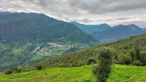 Un paisaje montañoso con un pequeño pueblo ubicado en el valle.
