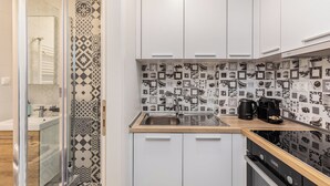 Una cocina moderna con armarios blancos, un salpicadero estampado y una cafetera sobre la encimera.