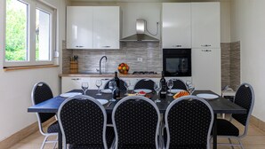 Een moderne keuken met witte kasten, een roestvrijstalen afzuigkap en een inbouwoven.