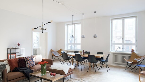 A modern living room with a sofa, coffee table, and dining area with chairs. - Hotel-standard design apartment with sea view (Helsinki)