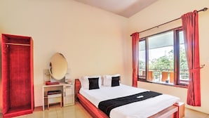 Un dormitorio con cama de madera, una mesita de noche, un espejo y una ventana con cortinas.