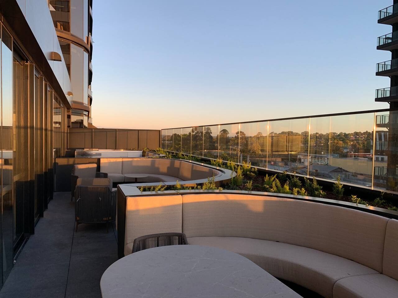 A rooftop terrace with outdoor seating and a view of the cityscape.