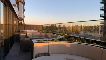 A rooftop terrace with outdoor seating and a view of the cityscape.