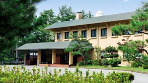 A two-story building with a flat roof, a covered entrance, and a small annex. - Hotel Wellness Notoji (Hodatsushimizu-cho)