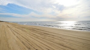 A sandy beach with gentle waves and a clear sky. - Hotel Wellness Notoji (Hodatsushimizu-cho)