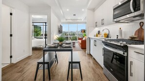 A modern kitchen with a built-in microwave, oven, and a dining area with a table and chairs.