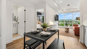 A modern kitchen with a dining table, a bench, and a view of the outdoors.