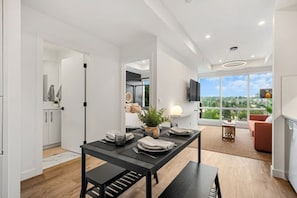 Uma cozinha moderna com uma mesa de jantar, um banco e vista para o exterior.