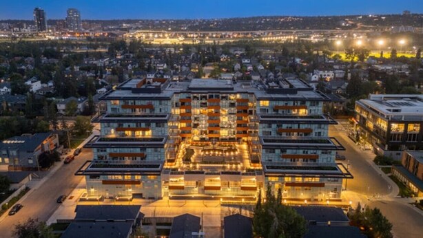 A multi-story hotel with a central courtyard, surrounded by residential buildings.