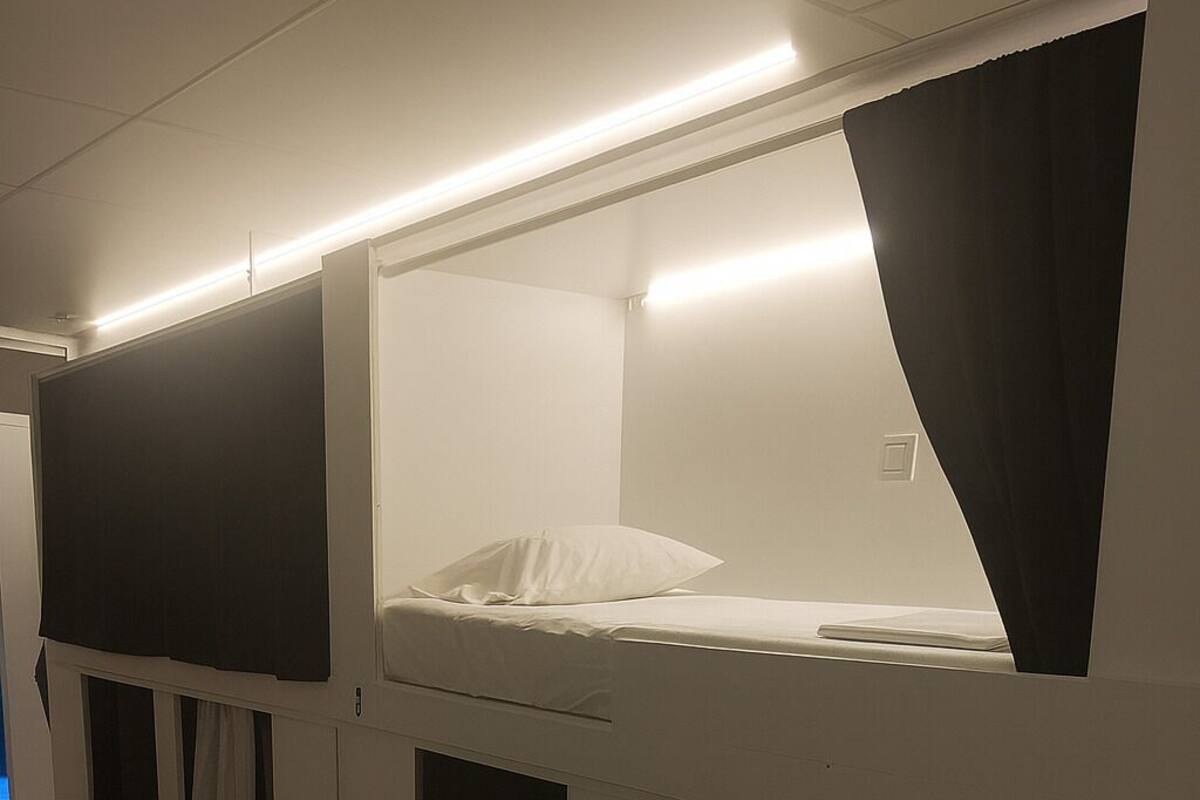 A room with bunk beds, a small stool, and a number '4' on the wall.