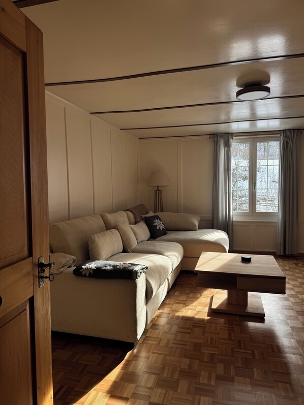 A modern living room with a sectional sofa, a wooden coffee table, and a floor lamp.
