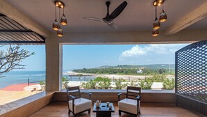 A balcony with two chairs, a table, and hanging lamps. - Amã Stays & Trails Athaang, Dapoli (Dapoli)