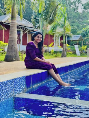 Una persona sentada en el borde de la piscina.