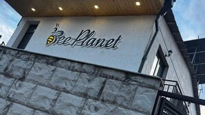 A building with a sign that reads 'Bee Planet' and a logo featuring a bee.