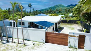 A beachfront property with a white building, a blue roof, and a wooden gate.