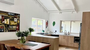 A modern kitchen with a central island, wooden cabinets, and a ceiling fan.