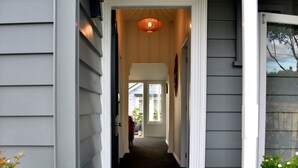 Ein Hauseingang mit Veranda, einer Treppe und einem Weg zum Eingang.
