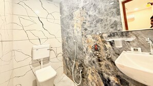 Un baño con inodoro, bidé y lavamanos.