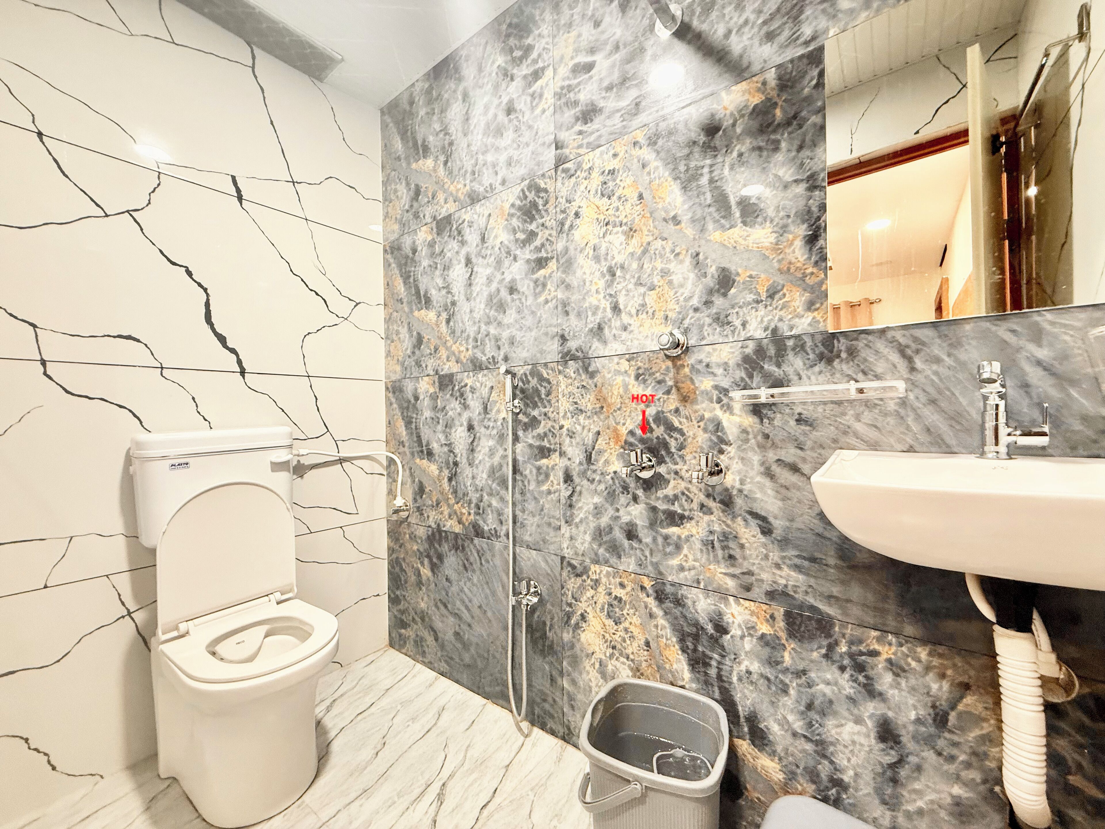 A bathroom with a toilet, shower, and sink.