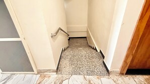 Una escalera estrecha con barandilla que lleva a una plataforma con una puerta.