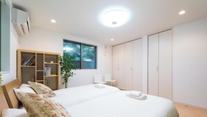 Un dormitorio con cama, armario, escritorio y ventana.