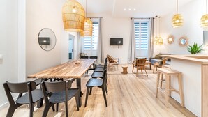 A modern kitchen with a wooden table, black chairs, and hanging rattan lights. - Smartstay - Suites Opera Barbara 3CH/8P (Lyon)
