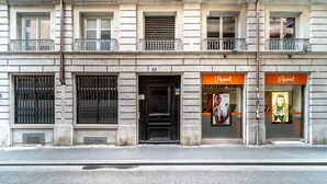 A building with a black door, two windows with metal bars, and a balcony with a railing. - Smartstay - Suites Opera Barbara 3CH/8P (Lyon)