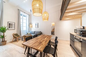 Eine moderne Küche mit Holztisch und -stühlen, einem Essbereich mit einer Couch und einer Treppe, die in ein Obergeschoss führt.