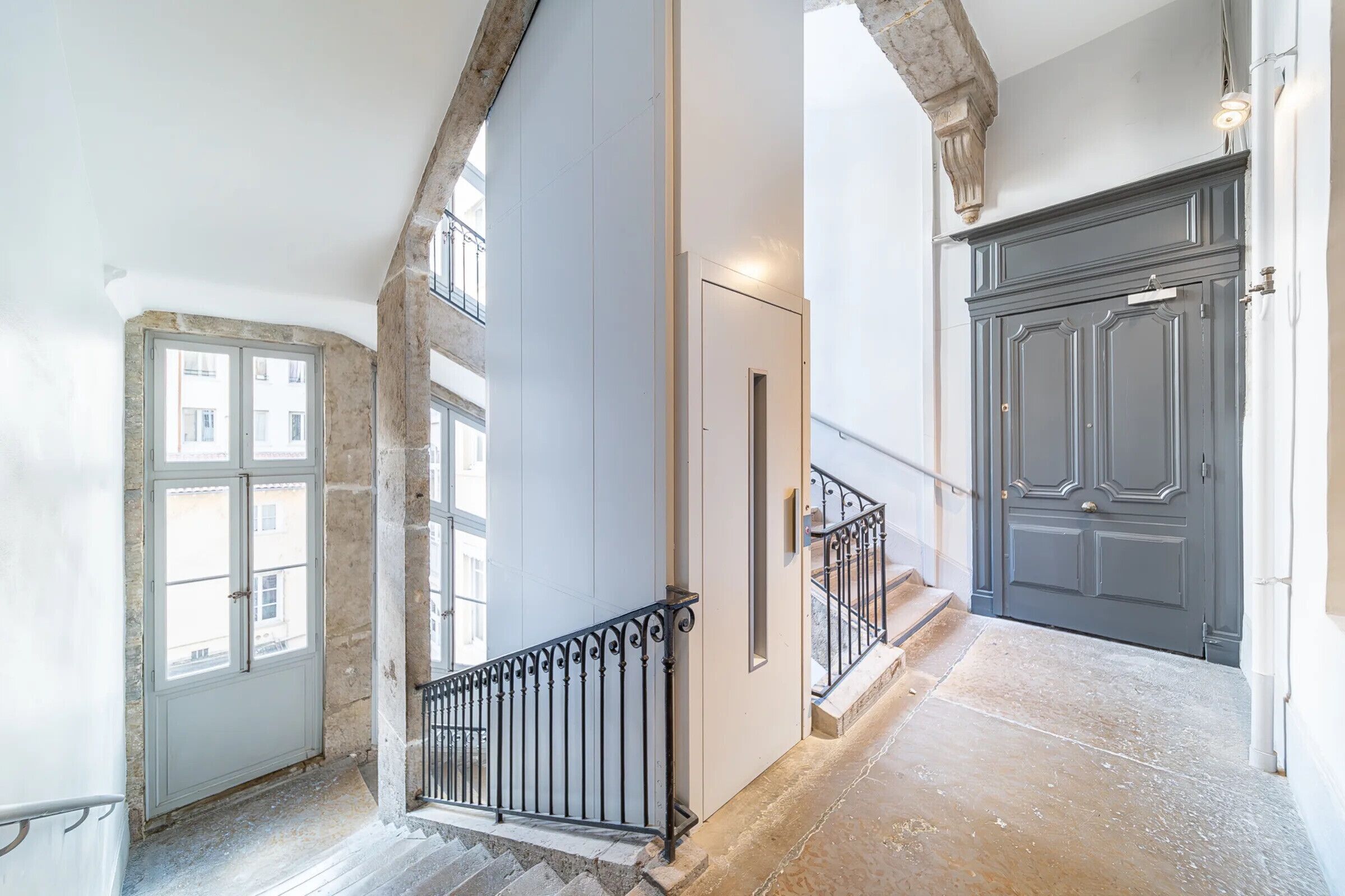 A staircase with a black railing leading to a door with a handle.