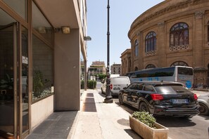 A street view with a building featuring large windows and a modern design. - Massimo Foyer - Rigoletto Suite by Wonderful Italy (Palermo)