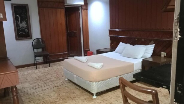 A hotel room with a bed, a desk, a chair, and a wardrobe. - T'BOLI HOTEL (General Santos)