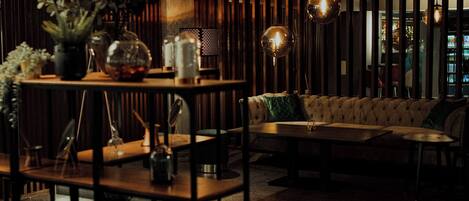 Un intérieur moderne avec une table en bois, un canapé et des luminaires suspendus.