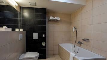 A modern bathroom with a toilet, a bathtub, and a towel rack.