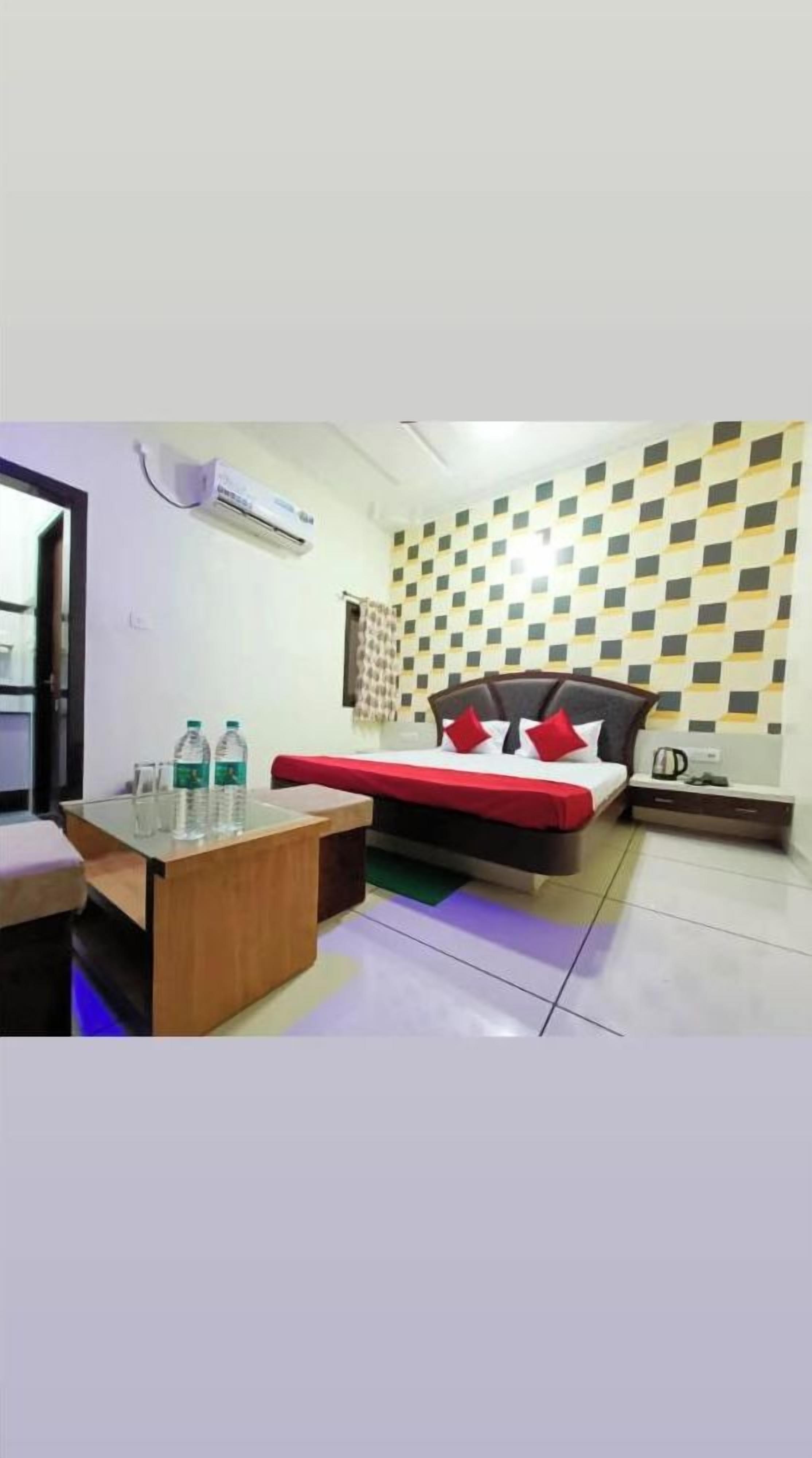 Une chambre d’hôtel avec un lit, une table de chevet, un appareil de climatisation et un mur décoré d’un motif.