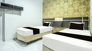 A hotel room with two beds, a large mirror, and a wall-mounted air conditioning unit. - OYO 94781 Hotel Lucky Inn Makassar (Makassar)
