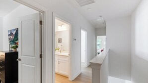 A modern interior with a hallway leading to a kitchen and a dining area. - Uptown Retreat Sleeps 10 w/Hot Tub, Games /Fenced (Charlotte)
