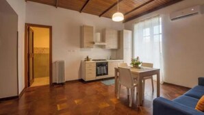 A compact living space with a kitchen, dining area, and a sofa. - SAMPOLO70 APARTMENTS (Palermo)