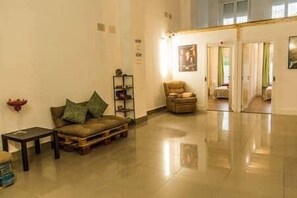 A spacious lobby with a leather sofa, a small table, and a bookshelf. - Isabel Guest House, Room 3 (Madrid)
