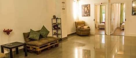 A spacious lobby with a leather sofa, a small table, and a bookshelf.